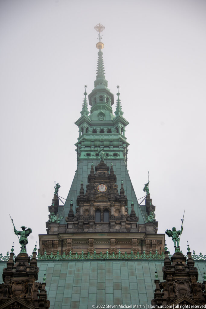 Upper Hamburg Rathaus roof pavilion with sculpted figures, green copper cladding, and tower rising above the main roof.