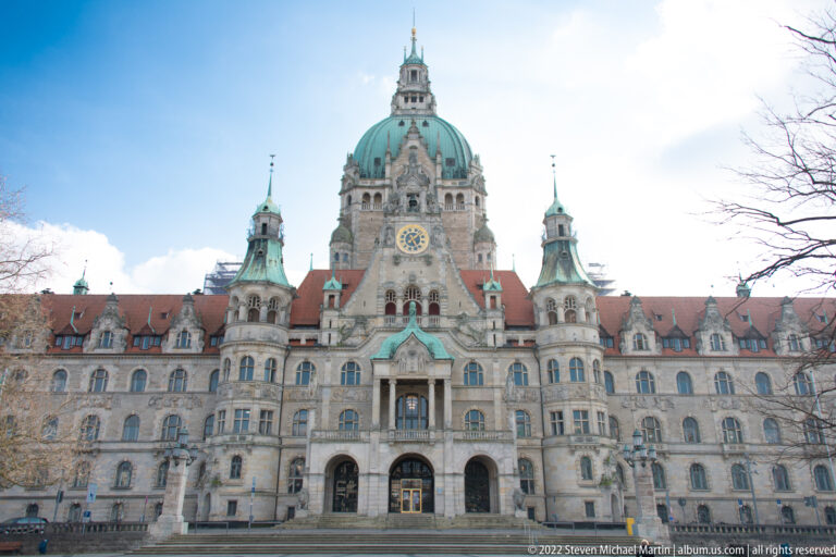 Closer frontal view of Hannover’s Neues Rathaus with green dome, central entrance, arched windows, and red roofs.