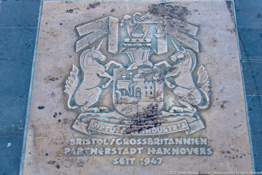Pavement plaque with coats of arms and German text commemorating Hannover’s partnership with Bristol since 1947.