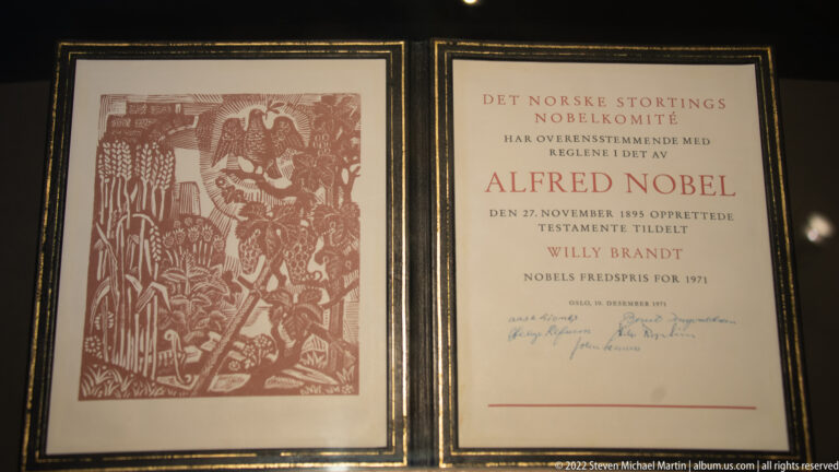 Framed Nobel Peace Prize diploma naming Willy Brandt and the 1971 award, paired with a monochrome illustration.
