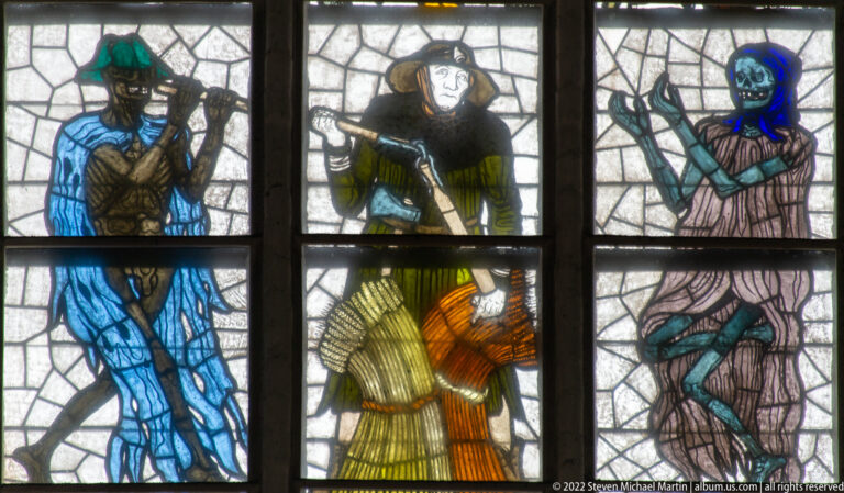 Human figure between two skeletal Death figures in Alfred Mahlau’s Lübeck Dance of Death stained-glass cycle.