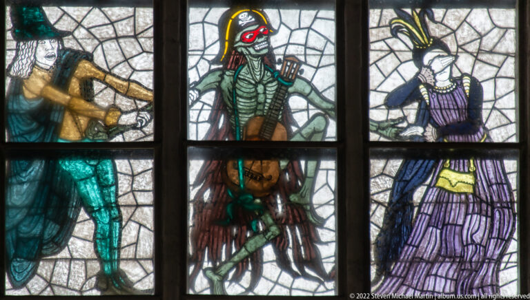 Armored and courtly figures beside Death in a colorful section of Alfred Mahlau’s Lübeck Dance of Death stained-glass window.