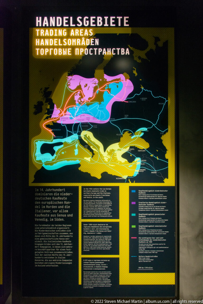 Illuminated museum map with brightly colored overlapping regions and route lines illustrating Hanseatic commercial geography.