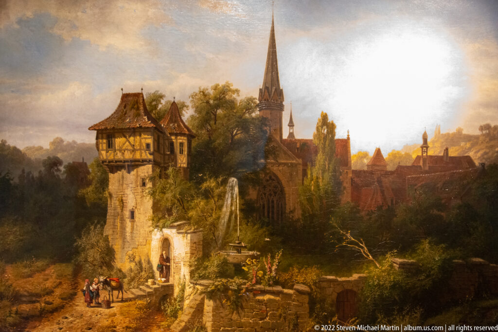 Romantic landscape painting with timber-topped tower, fountain, figures, and church spire among red-roofed monastery buildings.