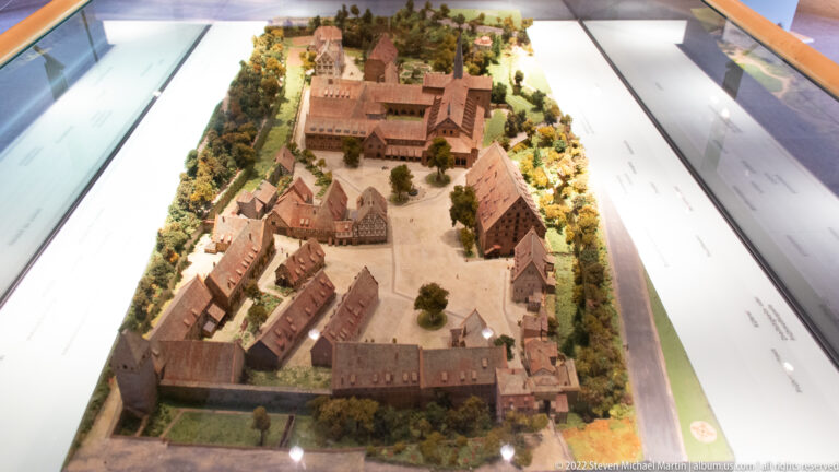 Architectural scale model of Maulbronn Monastery showing red-roofed buildings, courts, perimeter walls, and surrounding landscape.