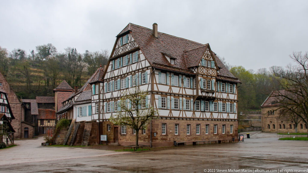 Large half-timbered building with stone lower story and steep tiled roof standing in the Maulbronn Monastery precinct.
