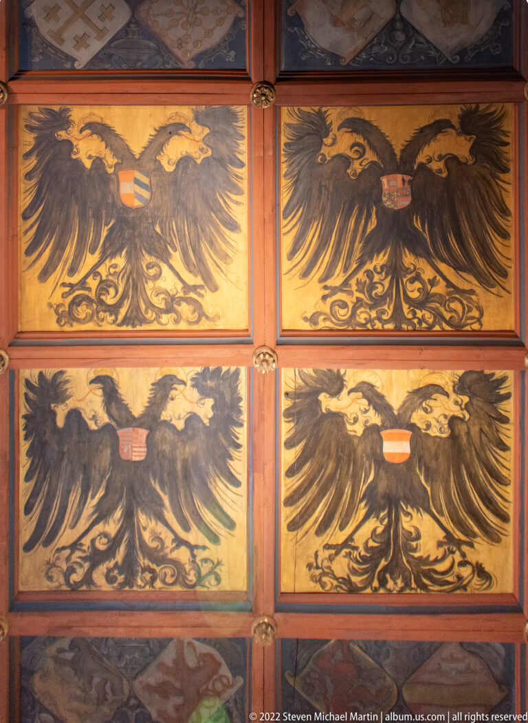 Four painted panels with black double-headed imperial eagles on gold backgrounds and small central shields.