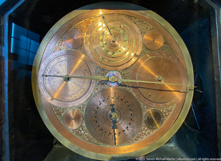 Circular brass instrument with multiple engraved dials, rotating discs, pointers, and decorated calibrated scales.