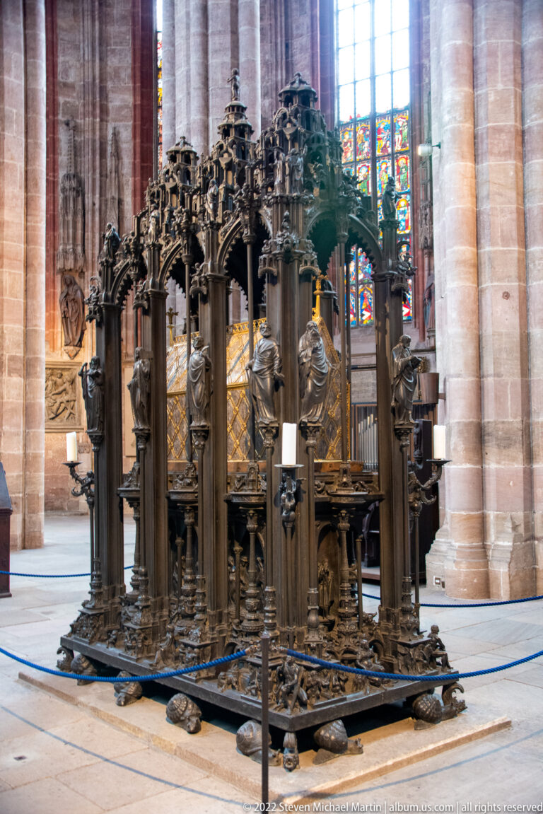 Freestanding bronze shrine of Saint Sebald with open canopy, columns, figures, and gilded reliquary core.