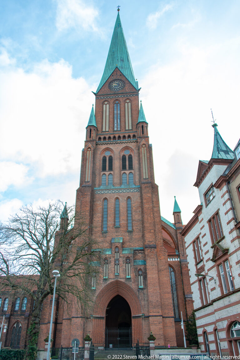 Frontal low-angle view of Schwerin Cathedral’s brick west tower and pointed entrance.