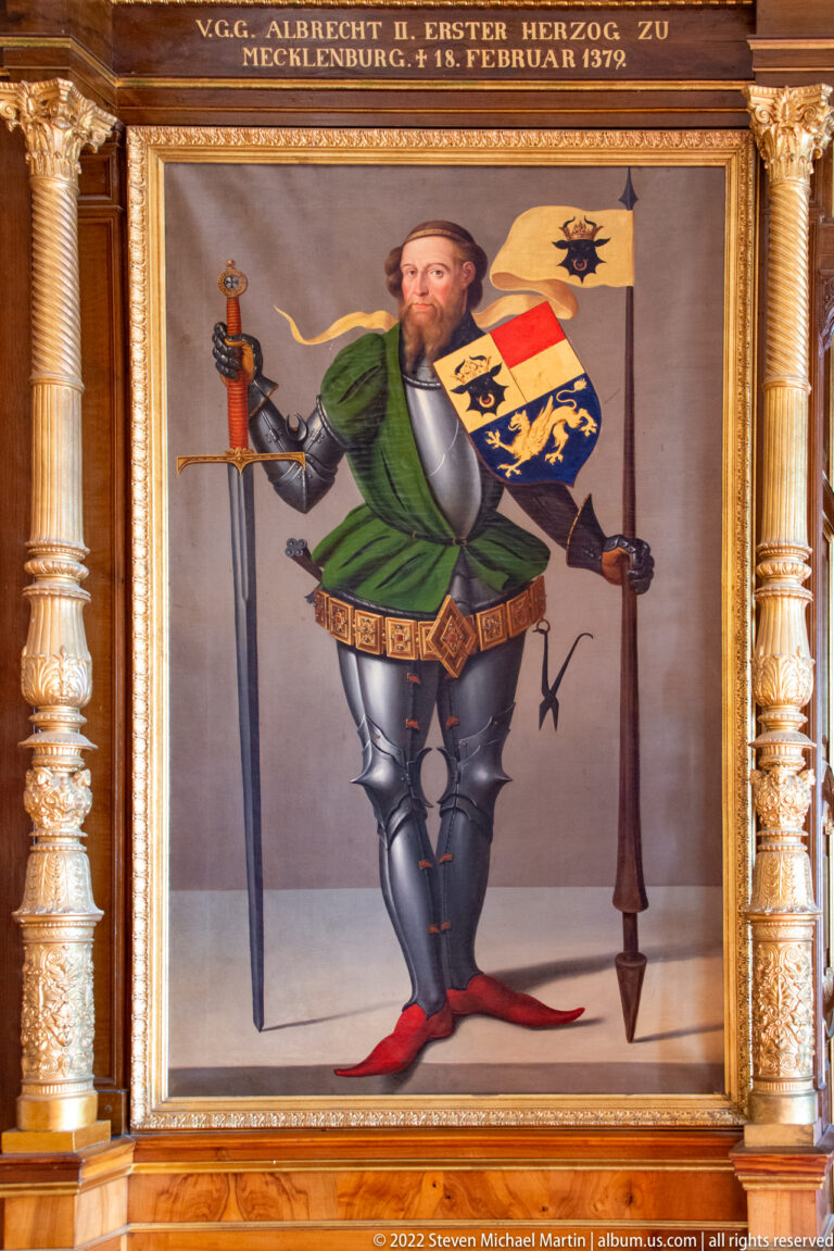 Full-length armored portrait of Albrecht II with sword, shield, heraldry, and identifying inscription above.
