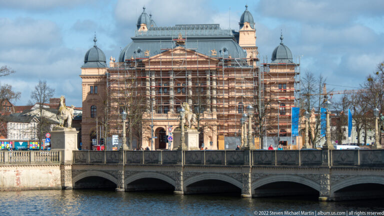 Scaffolded Mecklenburgisches Staatstheater beyond the arched Schlossbrücke and water in Schwerin.