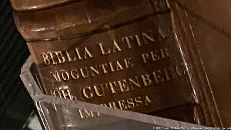 Close view of brown leather book binding with gilt spine text including BIBLIA LATINA and GUTENBERG.