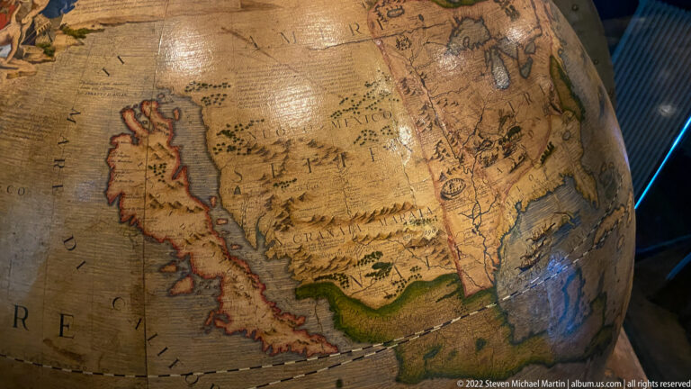 Close view of North America on an aged historic terrestrial globe with engraved coastlines, rivers, mountains, and place names.