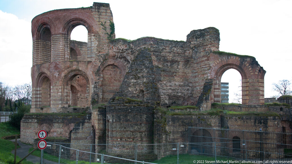 Ruins of Trier's Imperial Baths with massive Roman brick walls, tall arches, broken vaults, and exposed substructures.