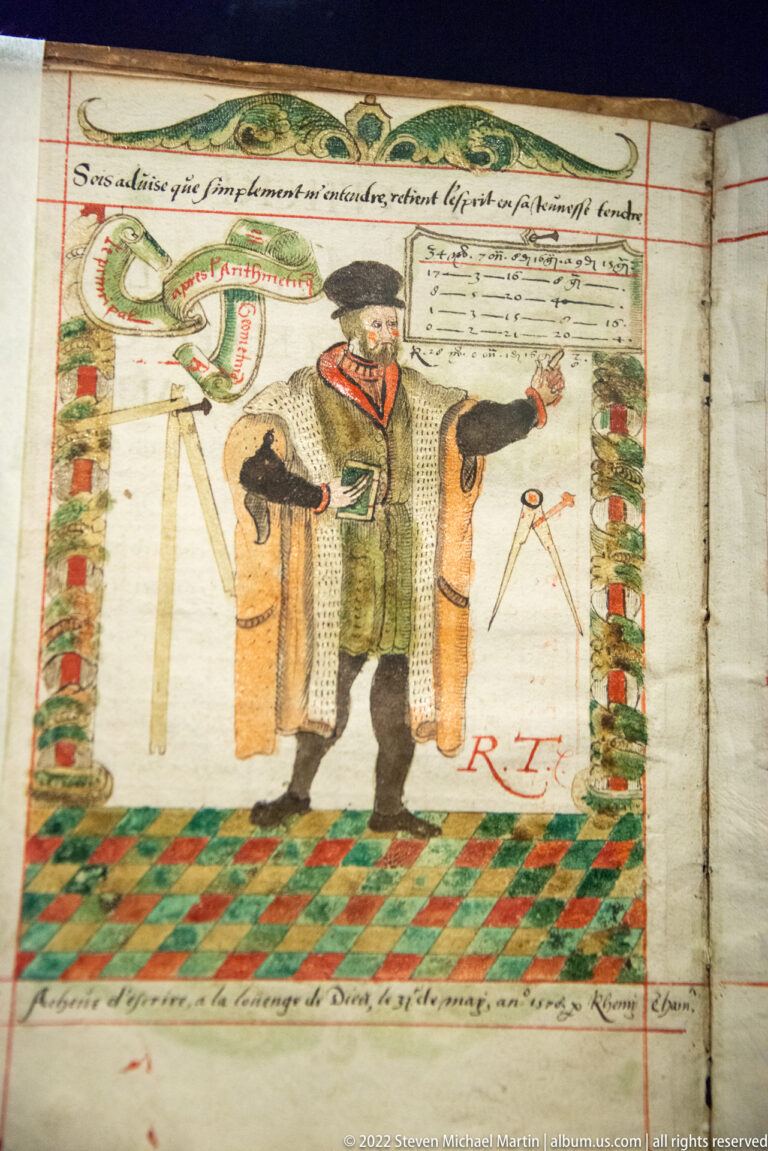 Colored manuscript drawing of a standing man beside large cylindrical forms, measuring tools, geometric motifs, and handwritten text.