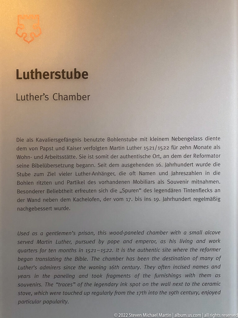 Bilingual museum panel headed 'Lutherstube / Luther's Chamber' with German and English explanatory text.