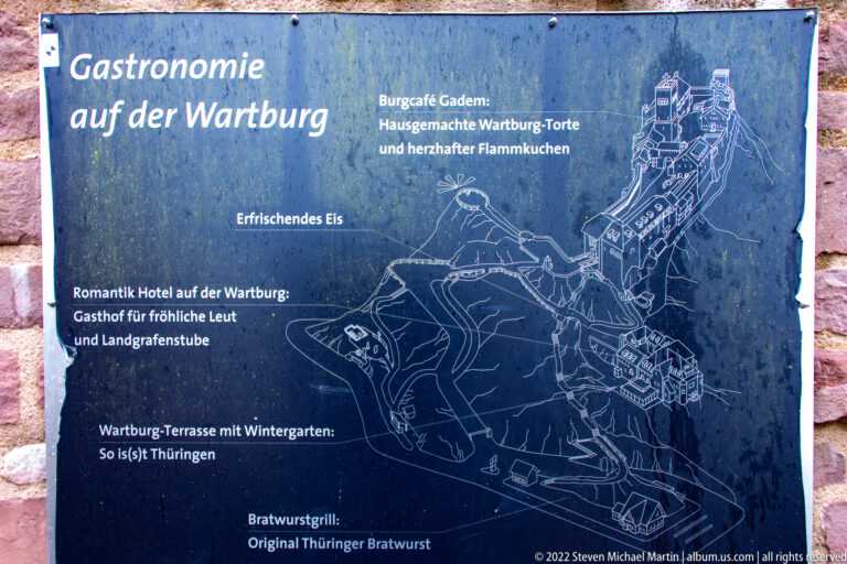 Blue visitor information panel with a line map of Wartburg Castle and German labels for on-site facilities.