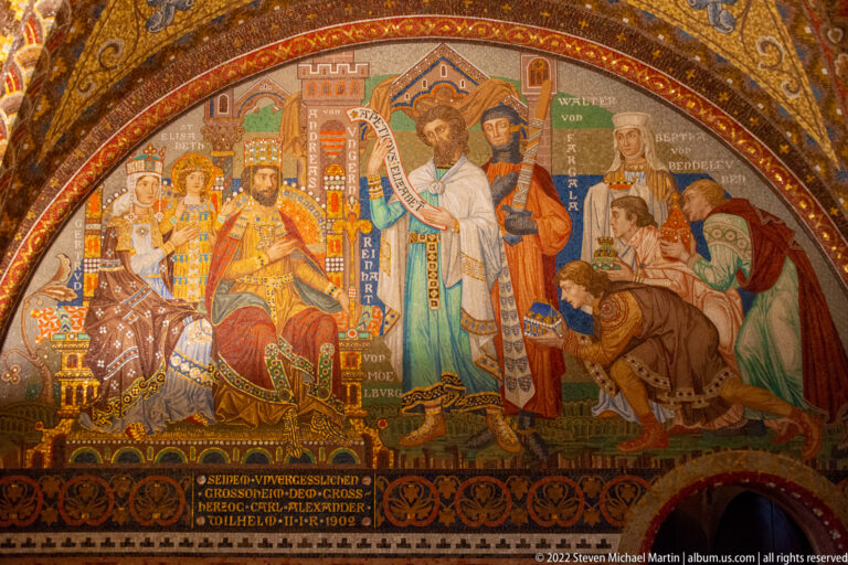 Mural showing a seated ruler facing a tall cleric, surrounded by courtiers and attendants.