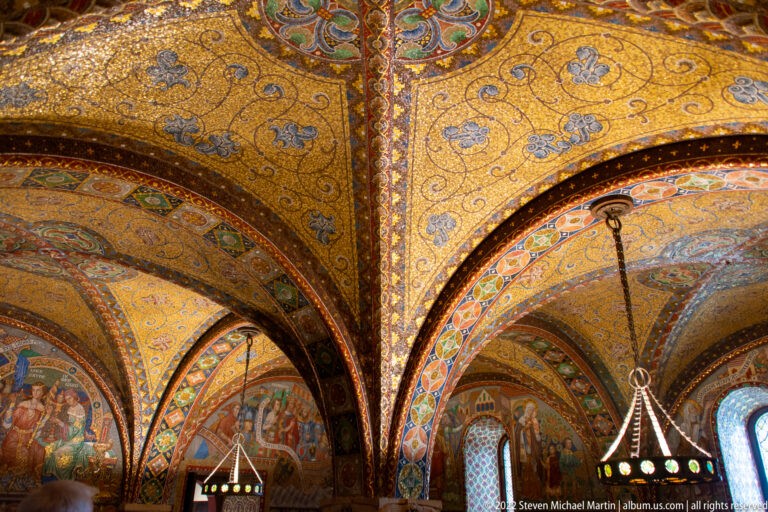 Wide view of richly decorated vaulted ceiling and mural-covered walls in a Wartburg interior.