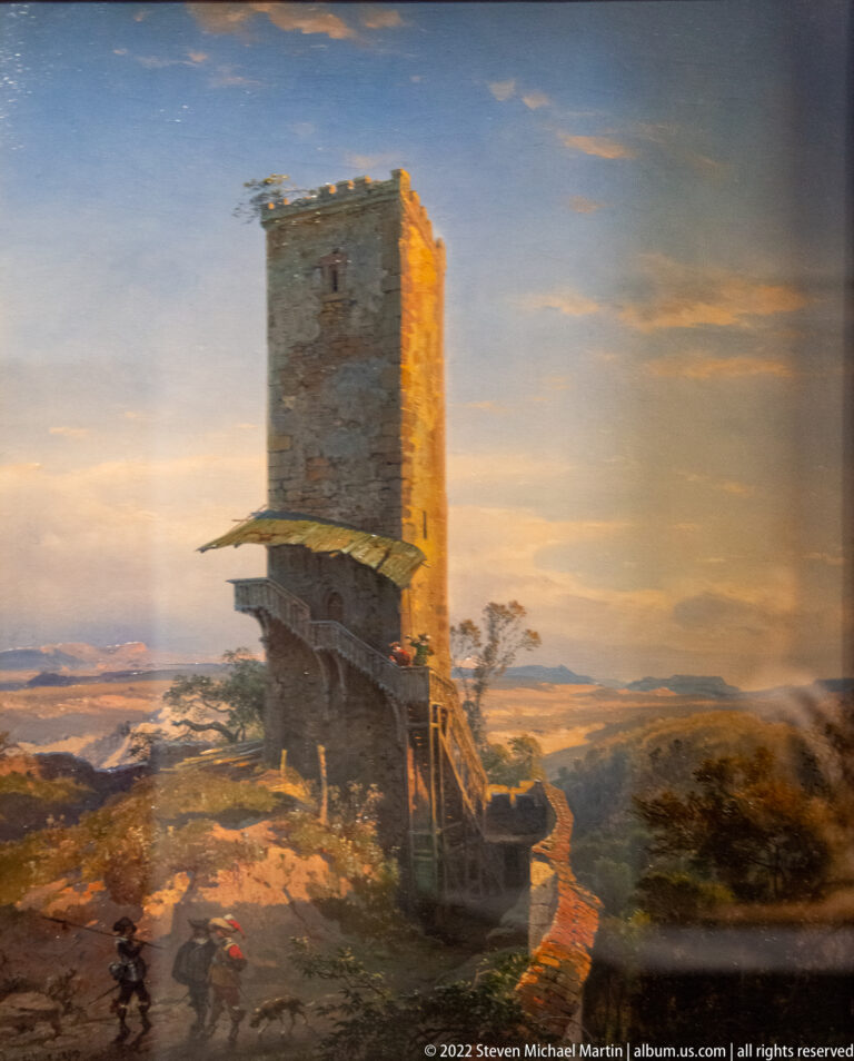 Painting of a tall ruined stone tower in a rocky landscape beneath a dramatic sky.