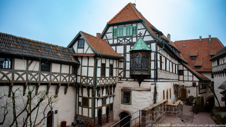 Half-timbered Wartburg courtyard with steep red roofs and a tall projecting bay window.