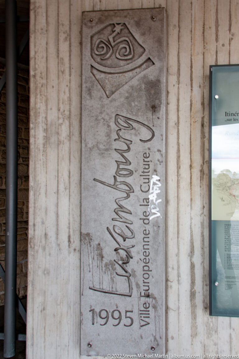 Wall inscription reads 'Luxembourg 1995' and 'Ville Européenne de la Culture' beside a stylized emblem.