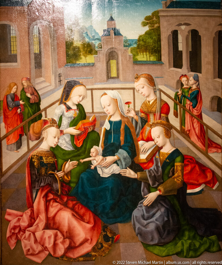 Religious panel painting with the seated Virgin and Child surrounded by richly dressed women on an architectural terrace.