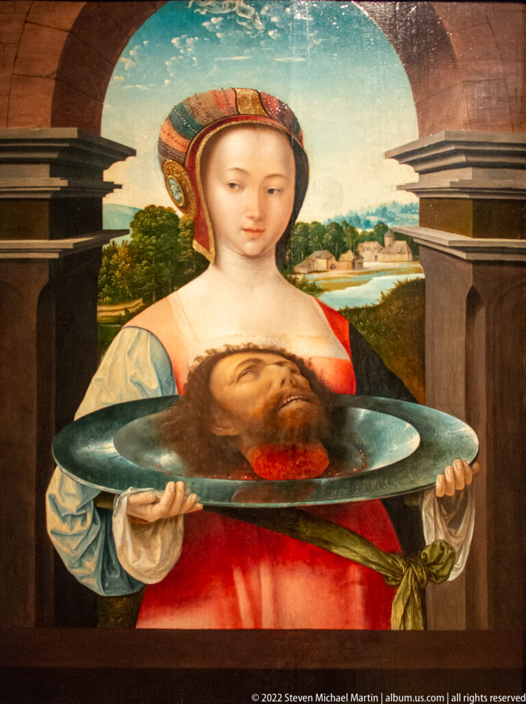 Young woman in elaborate dress holding a platter with the severed head of Saint John the Baptist.