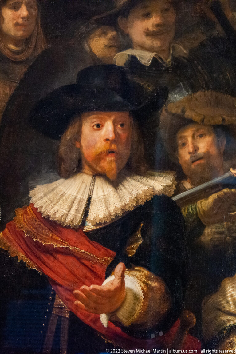 Close detail from The Night Watch of Captain Frans Banninck Cocq extending his hand, with another guardsman behind.
