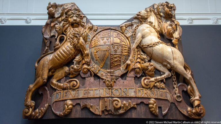 Carved British royal coat of arms with lion and unicorn supporters above the motto DIEU ET MON DROIT.