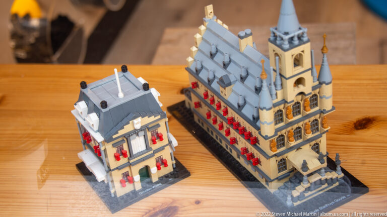 Two LEGO-style models of Dutch historic buildings with stepped gables, tower, and red window details.