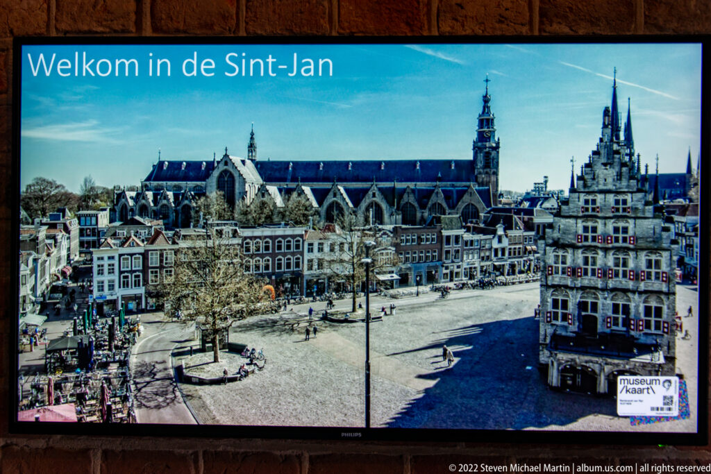 Display panel showing Sint-Janskerk behind Gouda’s market square and rows of historic buildings.