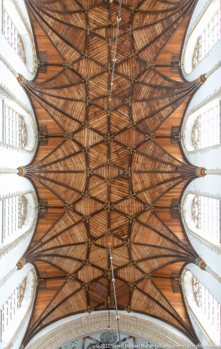 Upward symmetrical view of the Grote Kerk’s timber nave vault, ribs, trusses, and rows of clerestory windows.