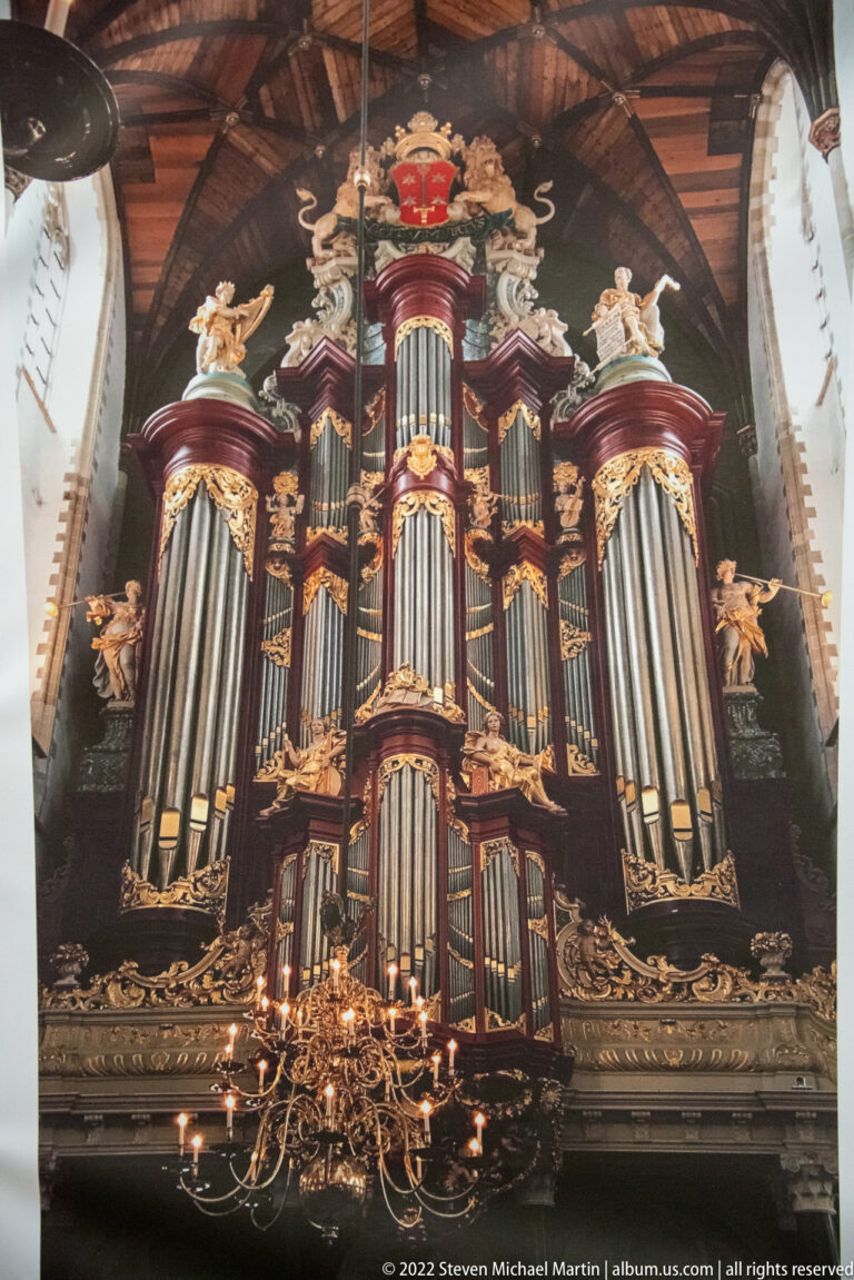 Monumental Christian Müller pipe organ with silver pipes, dark carved case, gilding, and sculpture inside Haarlem’s Grote Kerk.