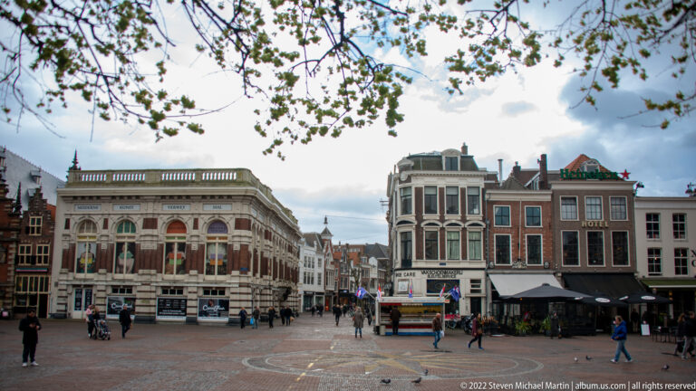 Historic façades, cafés, bicycles, and pedestrians lining a broad paved square in central Haarlem.