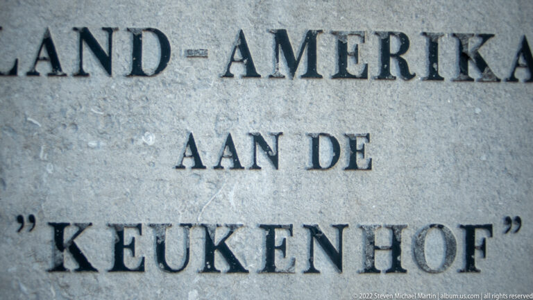 Close-up of carved or applied Dutch inscription with visible words “AMERIKA” and “AAN DE ‘KEUKENHOF’.”