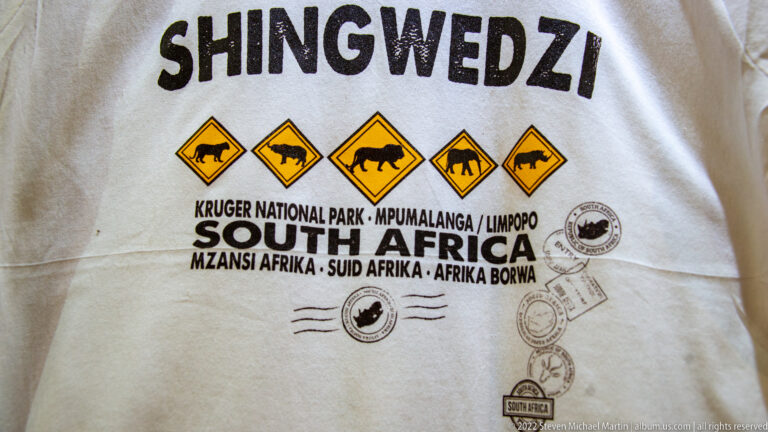 Shingwedzi souvenir shirt printed with wildlife road-sign icons and Kruger National Park, South Africa text.