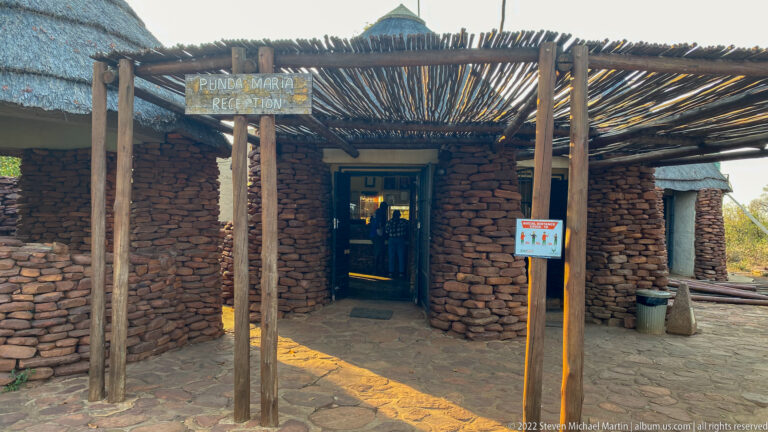 Stone-fronted Punda Maria Reception entrance beneath a rustic timber-pole canopy.