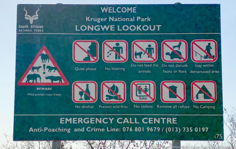 Green Longwe Lookout sign listing Kruger National Park safety rules, prohibitions, and emergency contact information.