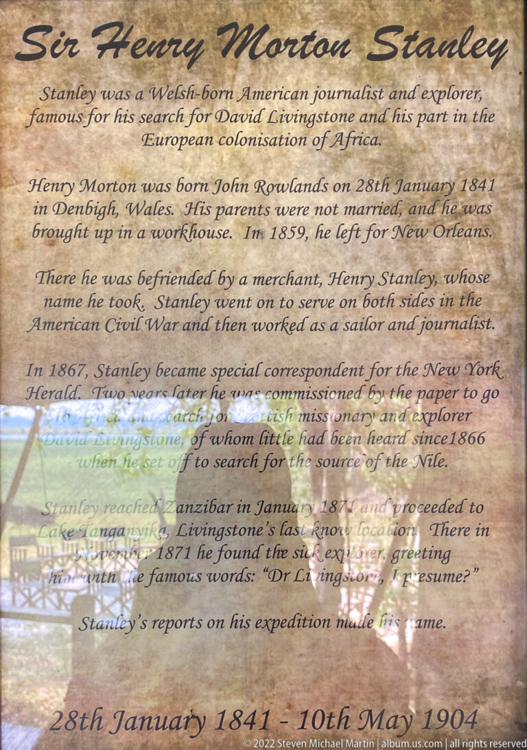 Weathered interpretive panel headed Henry Morton Stanley with biographical text and historic imagery.