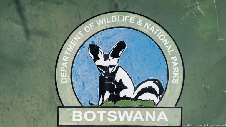 Circular Department of Wildlife and National Parks emblem with a stylized animal above the word Botswana.