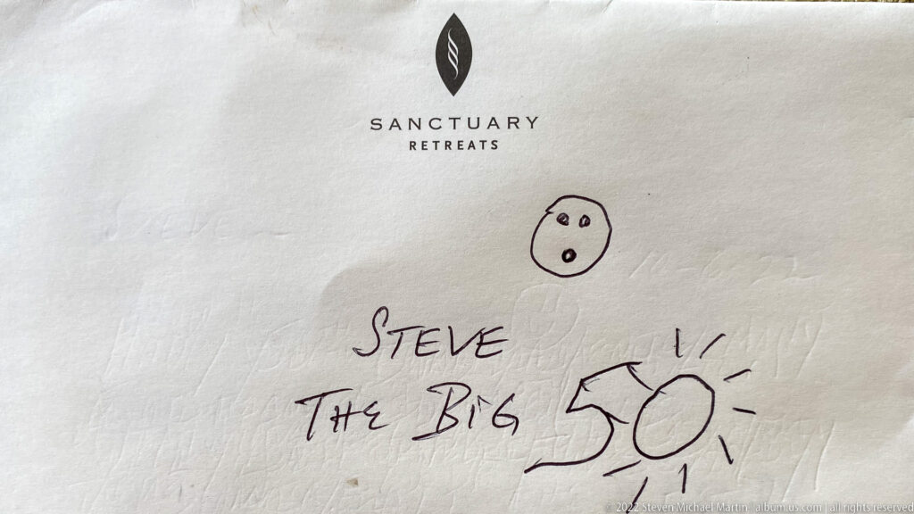 Sanctuary Retreats stationery with handwritten message reading “Steve The Big 50” and a small face drawing.