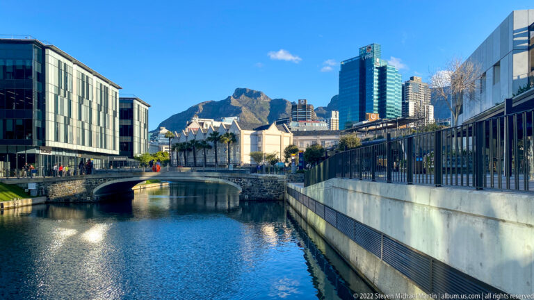 V&A Waterfront canal and low bridge framed by buildings, with Table Mountain rising in the distance.