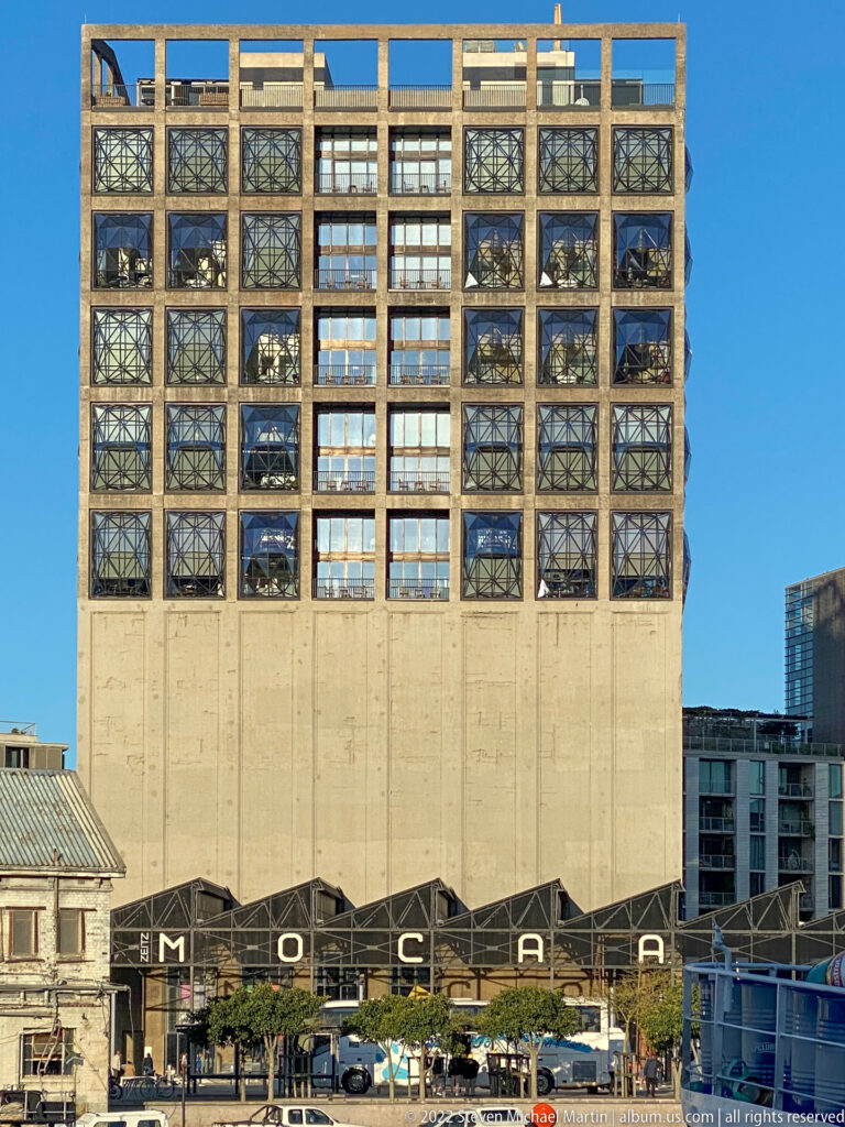 Tall concrete Zeitz MOCAA grain-silo building with a grid of faceted windows above the waterfront plaza.