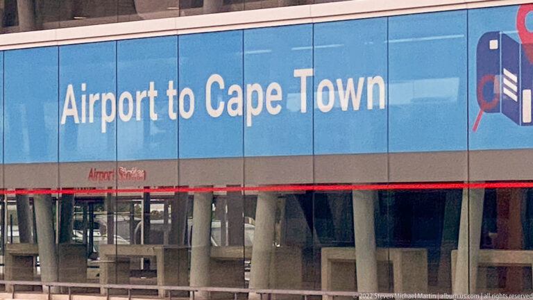 Large blue airport sign reading “Airport to Cape Town” above a glazed lower façade.