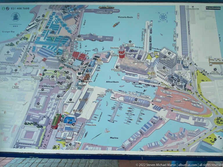 Detailed illustrated map of the V&A Waterfront showing basins, marina areas, streets, buildings, and visitor landmarks.