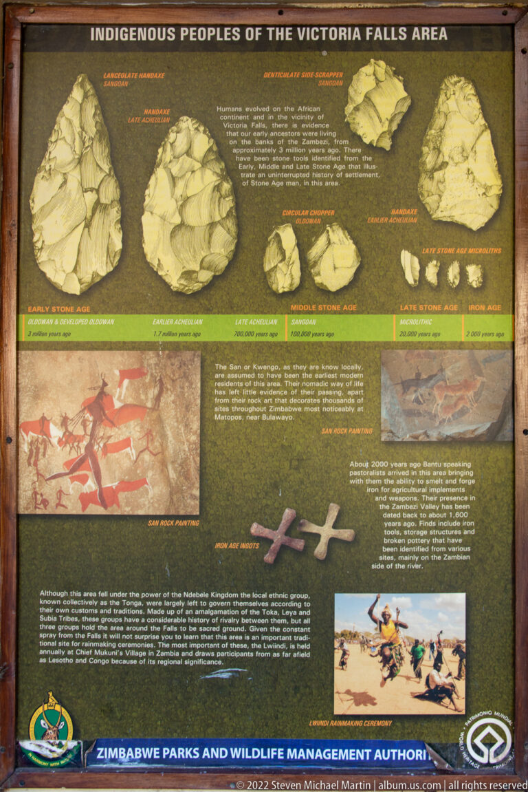 Interpretive panel showing prehistoric stone tools, rock-art scenes, and text about indigenous peoples of the Victoria Falls area.