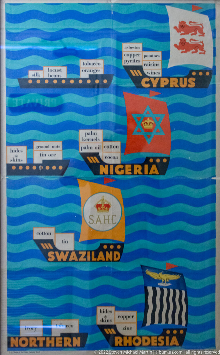 Detail of blue colonial trade panel with emblems and labels for Cyprus, Nigeria, Swaziland, and Northern Rhodesia.