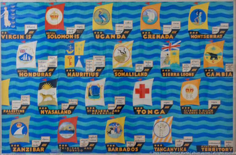 Blue colonial trade panel with historic emblems and territory names including Uganda, Grenada, Mauritius, Zanzibar, and Tanganyika.